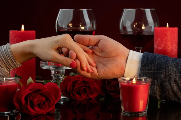 Red nail polish on a woman\'s hand, Manicure for a gala evening. The male hand gently holds female fingers.