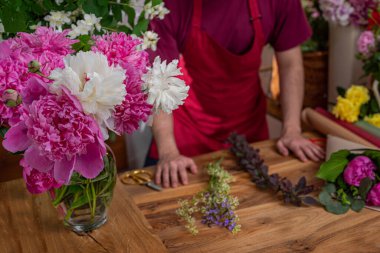 Çiçek açan şakayıklı cam vazo, çiçek satıcı. Çiçek işi. Buketlerin aranjmanı.