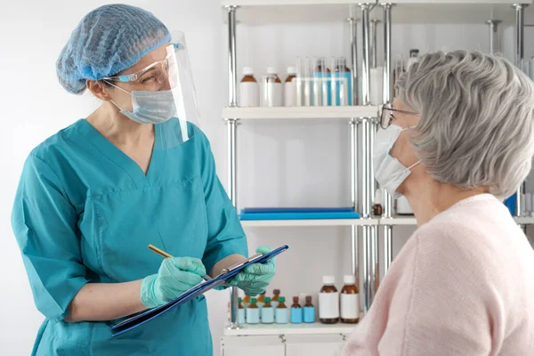 Female medical professional interviewing a senior lady adult woman. Hospital healthcare case