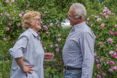 Gülümseyen mutlu yaşlı bayan ve erkek gülüyor, şaka. Bahar ya da yaz güneşli gün