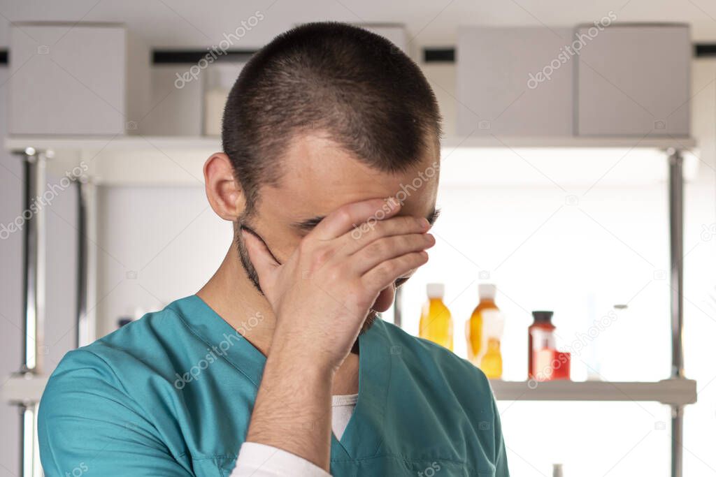 Young doctor man in medical apparel facepalm crying ashamed. Lifestyle outdoor scene