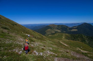 Gezginler dağdan ormana inerler. Turizm, açık havada tatil aktiviteleri. 17 Kasım 'da Ulusal Yürüyüş Günü