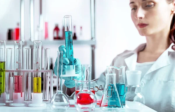 The laboratory assistant holding laboratory glass. Selected focus on beaker