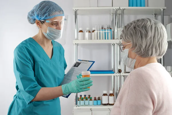 Enfermeira Segurando Uma Pasta Área Transferência Dando Medicamento Prescrição Frasco — Fotografia de Stock