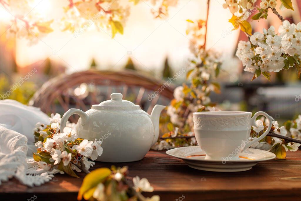 Tea set, cherry blossom branches, wooden table. Outdoor breakfast, picnic, brunch, spring mood. Soft focus