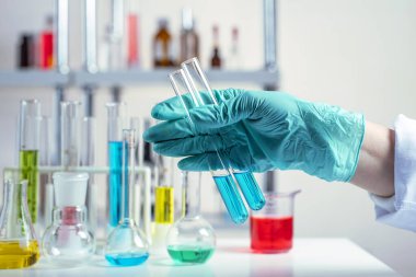 Eldivenin içinde test tüpüyle şarjör tutarken.