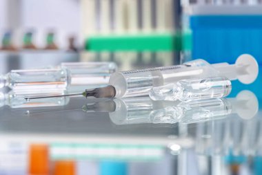 Sağlık ve tıbbi konsept - hastanede şırınga ve ampul ilaçlar. Yansımalı cam masa üstü, steril oda. Görüntüyü kapat