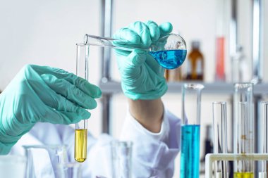 Eldivenli eller test tüplerine sıvı döküyor.