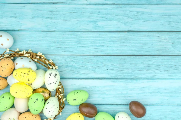 Paskalya tebrik kartı, takvim, poster, afiş. Çikolata, altın, dekoratif yumurta, açık mavi tahta çelenk