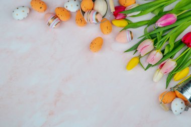 Bir buket taze lale dekoratif Paskalya yumurtası ve pembe mermer üzerinde kova. Kopya alanı kavramı bir tebrik kartı, pankart, takvim tasarımı için uygundur.