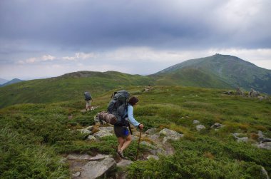 Sırt çantalı turistler tepe boyunca yürüyor. Turizm tatili aktivitesi. 17 Kasım 'da Ulusal Yürüyüş Günü