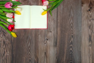 Çok renkli laleler, ahşap bir yüzeyde maket yapmak için not defteri. Kopyalama alanı olan çiçek arkaplanı