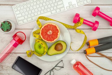 Sağlıklı yaşam tarzı kavramı. Haplar diyet takviyesi, tabak, avokado, portakal, greyfurt, brokoli, elma, akıllı telefon ve spor aksesuarları..