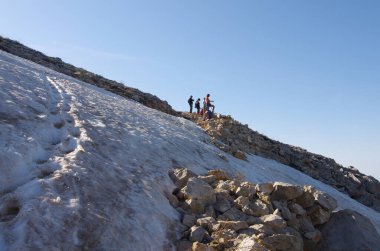 Dağın yamacında bir grup turist. Eriyen kar. Turizm tatili aktivitesi. 17 Kasım 'da Ulusal Yürüyüş Günü
