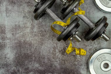 Sağlam yaşam tarzı ağırlık kaldırma konsepti tutuş demir olimpik ağırlık plakaları ve beton zeminde şerit ölçer. Boş kopyalama alanı