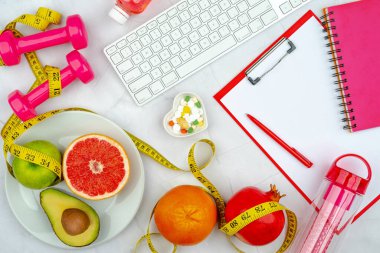 Eğitim ekipmanları, kalp şeklindeki plaka, diyet takviyesi hapları, klavye, dambıl ve mezura ile sağlıklı yaşam tarzı idmanı konsepti. Boş kopyalama alanı, kırpma tahtası maketi.