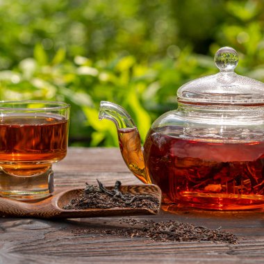 Buharda pişirilmiş cam çaydanlık, zarif bir fincan. Çaylı bambu kaşığı, ahşap masa. Açık hava, piknik, kahvaltı. Bulanık bir geçmişi var. Kırpılmış görünüm