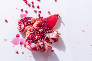 Tohumlu, sulu, kırmızı, sulu nar ve beyaz arka planda biraz meyve suyu. Diyet Taze Vegan Tatlısı