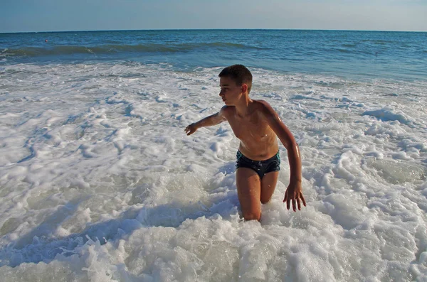 身穿泳衣的晒黑了的小男孩在度假和旅行时 在海浪中欢欣雀跃 — 图库照片