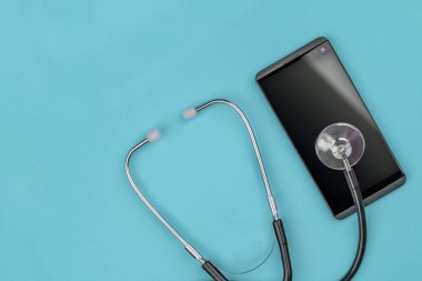 Steteskop ve akıllı telefon. Çevrimiçi yardım, çağrı merkezi, telefon ve elektronik onarım kavramı.