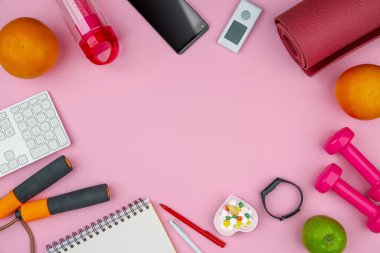 Eğitim ekipmanları ile sağlıklı yaşam tarzı çalışma konsepti. Spor yaparken ve zayıflatırken uyum ve uzun ömürlü olma fikri. Boş kopyalama alanı, maket yap, pembe arkaplan.