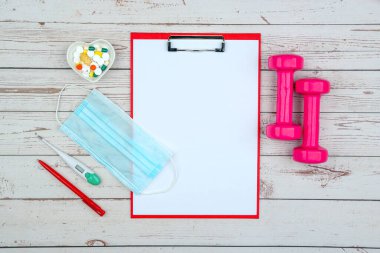 Eğitim ekipmanları ile sağlıklı yaşam tarzı çalışma konsepti. Salgın sırasında spor yaparken uyum ve uzun ömürlü olma fikri. Model için boş klip tahtası.