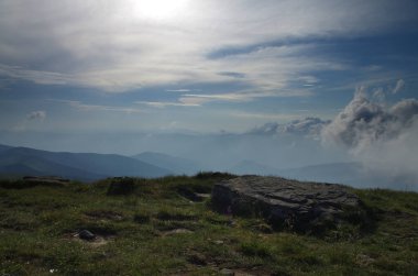 Yüksek dağlar, kayalar, taşlar. Dağ panoramik manzarası, bulutlar ve mavi gökyüzü. Turizm, seyahat, yeni deneyimler