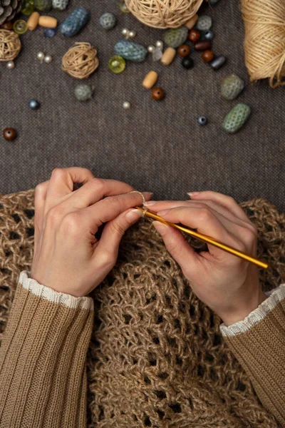 Tığ işi örgü ören kadın eller. Hobiler, el işleri ve el işi. İplikler, iplik yumakları, çizikler, bobinler, makaralar..