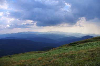 Yüksek dağlar, kayalar, taşlar. Dağ panoramik manzarası, bulutlar ve mavi gökyüzü. Turizm, seyahat, yeni deneyimler