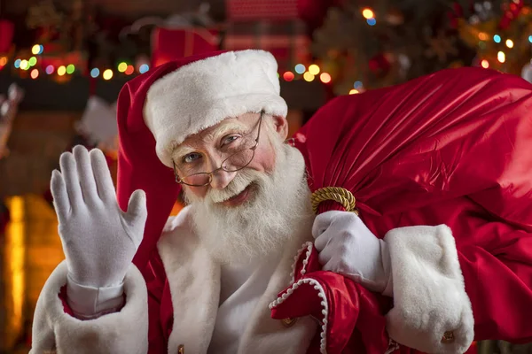 Noel Baba Şömine Noel Ağacının Yanında Hediyelerle Dolu Bir Çantayla — Stok fotoğraf