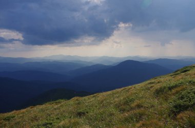 Yüksek dağlar, kayalar, taşlar. Dağ panoramik manzarası, bulutlar ve mavi gökyüzü. Turizm, seyahat, yeni deneyimler