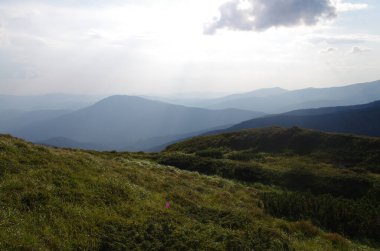 Yüksek dağlar, kayalar, taşlar. Dağ panoramik manzarası, bulutlar ve mavi gökyüzü. Turizm, seyahat, yeni deneyimler