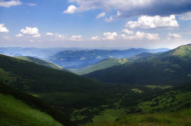 Yüksek dağlar, kayalar, taşlar. Dağ panoramik manzarası, bulutlar ve mavi gökyüzü. Turizm, seyahat, yeni deneyimler