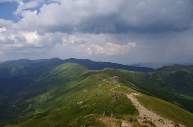 Yüksek dağlar, kayalar, taşlar. Dağ panoramik manzarası, bulutlar ve mavi gökyüzü. Turizm, seyahat, yeni deneyimler