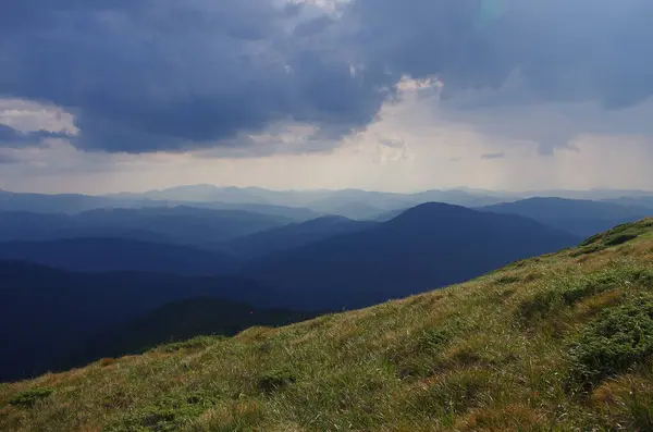 Yüksek dağlar, kayalar, taşlar. Dağ panoramik manzarası, bulutlar ve mavi gökyüzü. Turizm, seyahat, yeni deneyimler