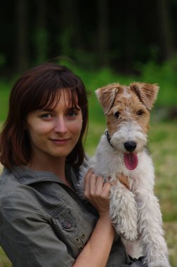 Yavru tel saçlı tilki teriyeri olan genç bir kadının portresi. Köpekli kız dışarıda.