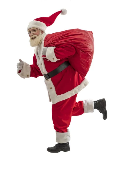 白色背景的圣诞老人被隔离了 老男演员 留着真正的白胡子 扮演圣诞老人的角色 拿着一袋礼物 跑来跑去 — 图库照片
