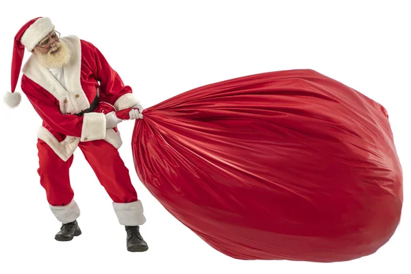 サンタクロースの白い背景に孤立した シニア男性俳優古いです男とともに本当の白い髭での役割の父クリスマス引っ張っ巨大な赤いクリスマス大きなギフトバッグ — ストック写真
