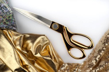 Özel dikim giysiler, dikiş aksesuarları. Altın makas, iplik, mermer bir masanın üzerindeki kumaşlar. Kadınsı, şenlikli, göz alıcı, akşam, gelinlik, nedime elbisesi..