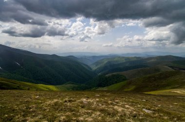 Yüksek dağlar, kayalar, taşlar. Dağ panoramik manzarası, bulutlar ve mavi gökyüzü. Turizm, seyahat, yeni deneyimler