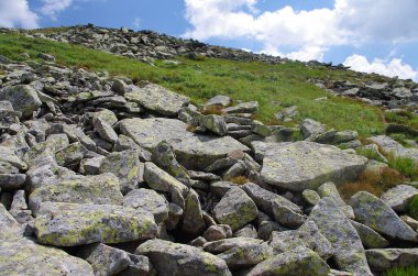 Yüksek dağlar, kayalar, taşlar. Dağ panoramik manzarası, bulutlar ve mavi gökyüzü. Turizm, seyahat, yeni deneyimler