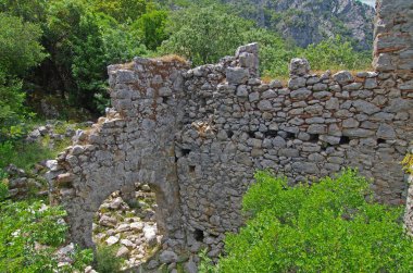 Eski taş kalıntıları. Şehir simgeleriyle dolu dağ manzarası. Kırık taş duvar dokuları. Açık havada eski binalar