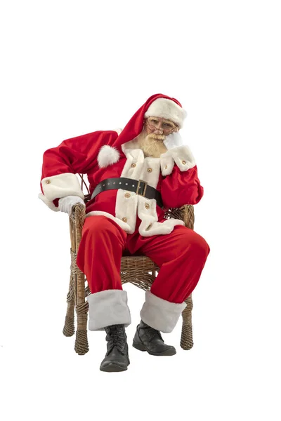 サンタクロースの白い背景に孤立した シニア男性俳優古いです男とともに本当の白いひげでザ父クリスマスの役割でザウィッカー柳の椅子に座って — ストック写真
