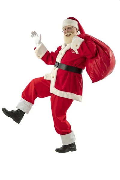 白色背景的圣诞老人被隔离了 老男演员 留着真正的白胡子 扮演圣诞老人的角色 拿着一袋礼物 跑来跑去 — 图库照片