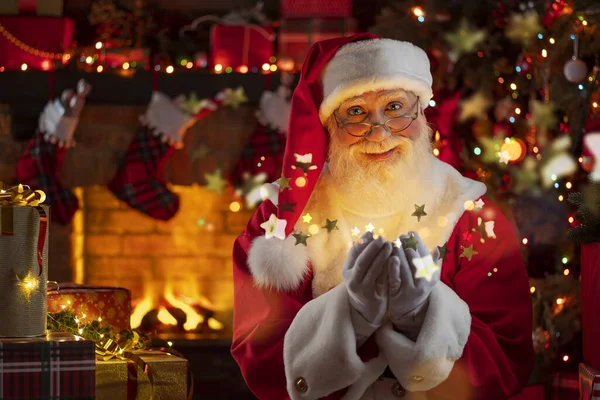 Noel Baba şöminenin yanındaki palmiyelerden ve Noel ağacından altın yıldızları üflüyor. Ahşap evin içindeki şenlikli iç mekan, Noel 'in neşeli ruhu. Gerçek beyaz sakallı son sınıf öğrencisi Noel Baba kostümü giyiyor..