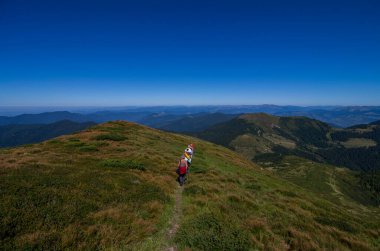  Bir grup yürüyüşçü dağ yamacından aşağı iniyor. Turizm, tatil aktivitesi, yürüyüş, sırt çantası, açık hava. 17 Kasım 'da Ulusal Yürüyüş Günü
