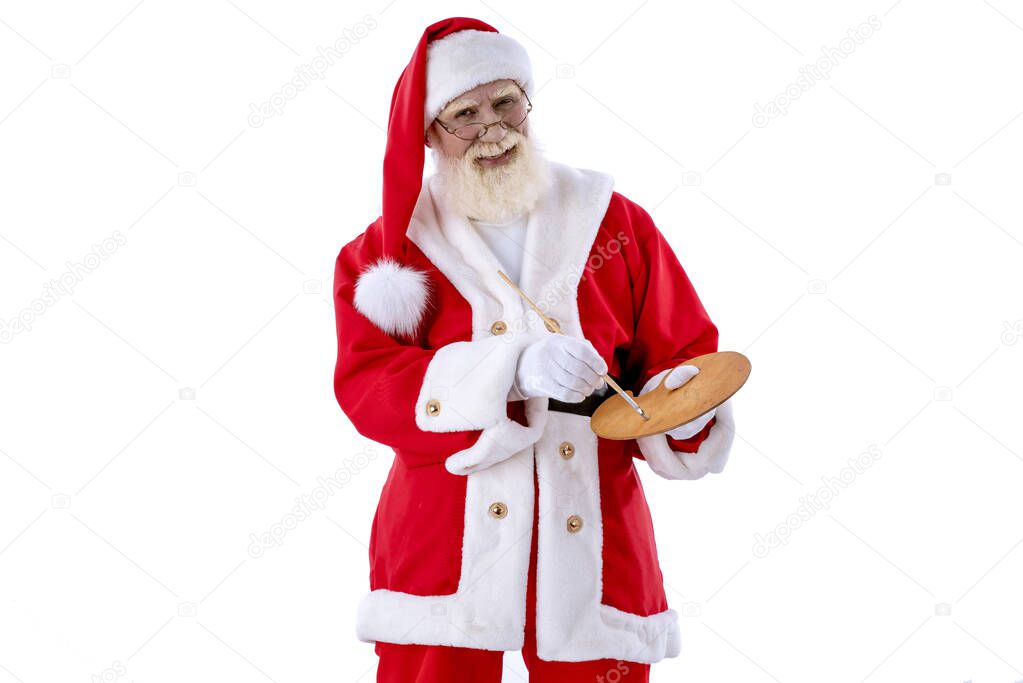 Santa Claus artist with brush and palette on white background isolated. Senior male actor old man with a real white beard in the role of Father Christmas