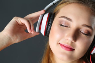 Gözleri kapalı kafa telefonu giyen güzel sarışın gülümseyen kadın