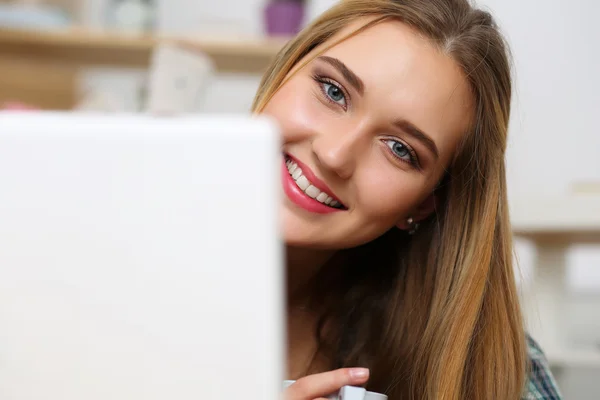 Hermosa rubia sonriente mujer acostada en el suelo con ordenador portátil comput — Foto de Stock