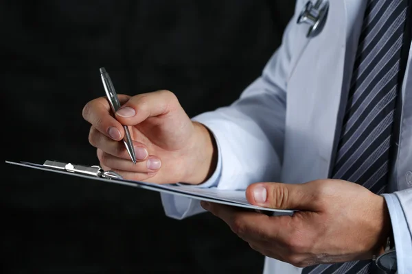 Médico masculino mano sosteniendo pluma de plata escritura —  Fotos de Stock